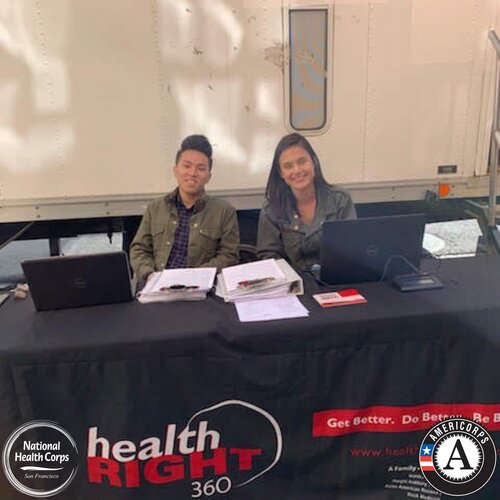 NHC SF AmeriCorps members Wesley and Kristin at a patient check-in table.