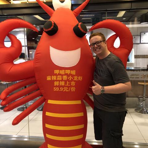 NHC PGH member Daniel smiling and thumbs up next to lobster mascot