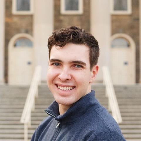 Jack is standing in front of a building.