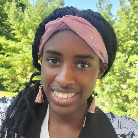 NHC member Maxine Smiles, wearing a pink headband and black and white shirt.