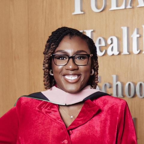 NHC member Leah Kimbrough wearing graduation attire and smiling.