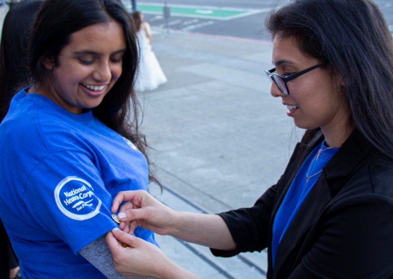 Shivani Bahl being pinned with the AmeriCorps pin by Program Director Nadia Majlessi.