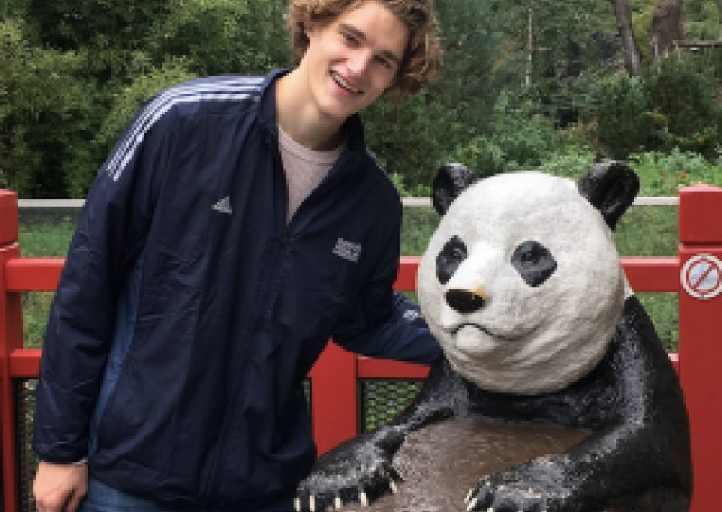 NHC PGH member Nate smiling posing with a panda statue