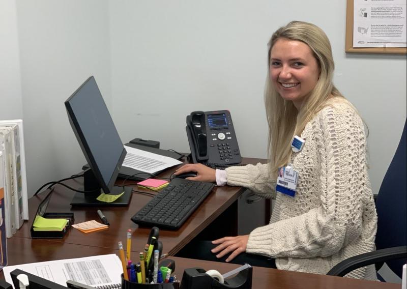 Olivia is pictured here at her host site working on Medicaid applications for families.