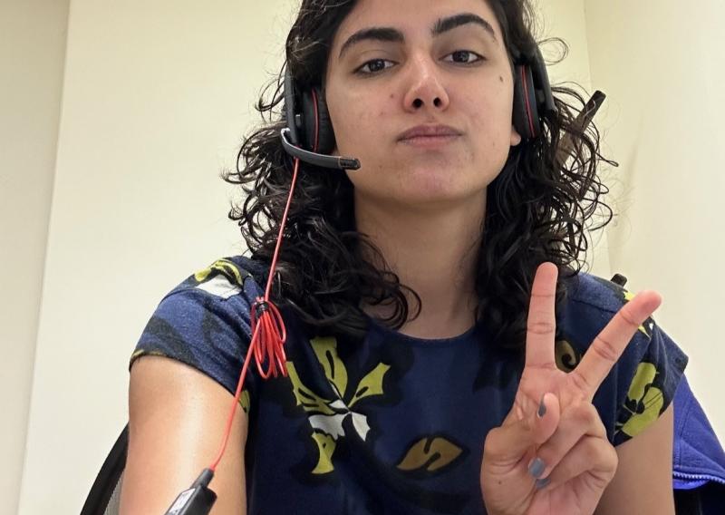 Alya Wilkinson-Hayat is facing the camera while at the DPH office. She is throwing up a peace sign.