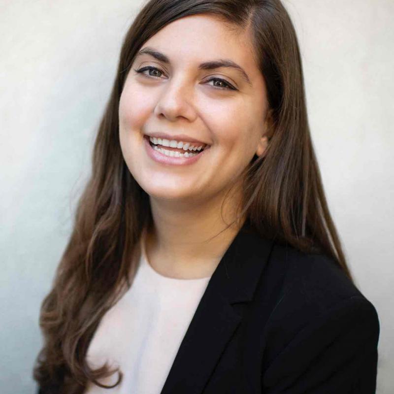 NHC member Elizabeth Brehman is wearing a Black blazer and white blouse, while smiling.