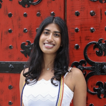 Sanjana smiling in front of a red door