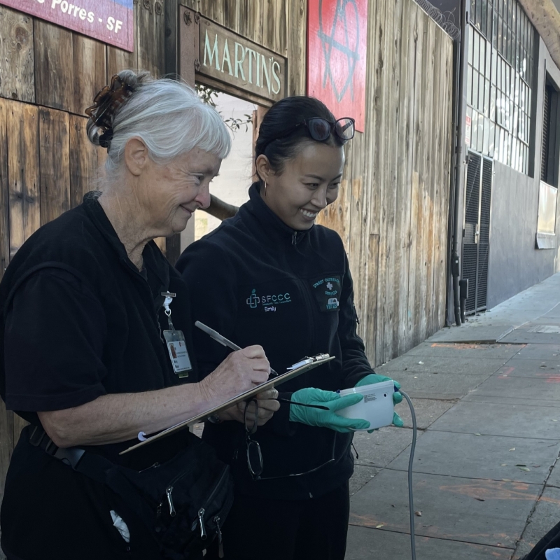 Emily J is seen doing outreach with a patient together with the SOS Resident Nurse.