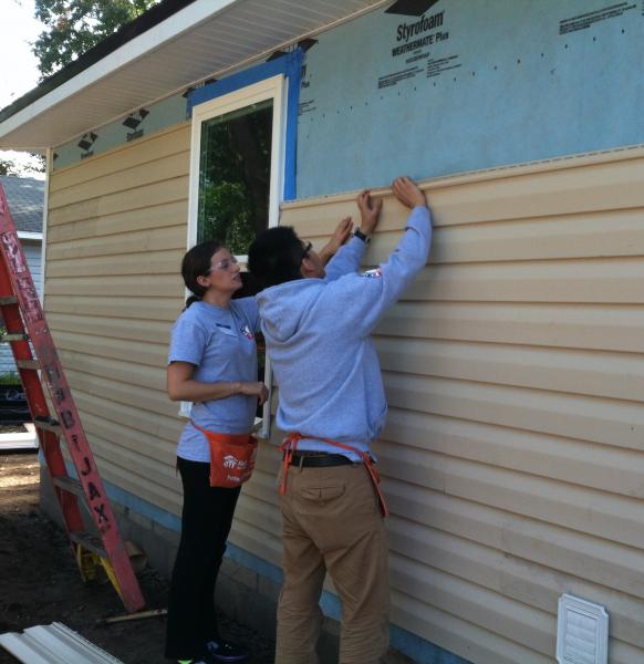 Picture of members installing siding on a house