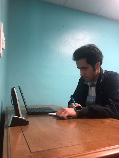 Armaan is researching and taking notes on a health theme to teach to his clients during the home visits with his clients this month