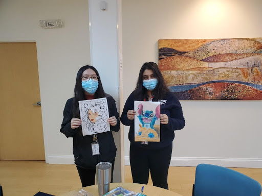 NHC members Roya and Jennifer hold up artworks created during art group with Gateway patients.